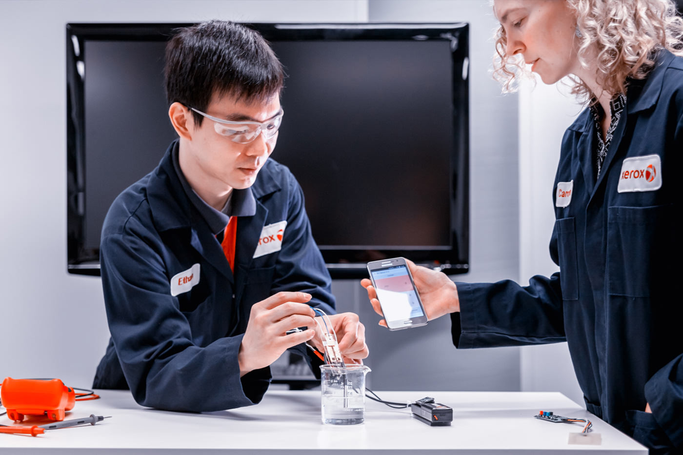 Technicians testing device on factory floor